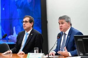 homens em sessão do plenario sentados atras da mesa