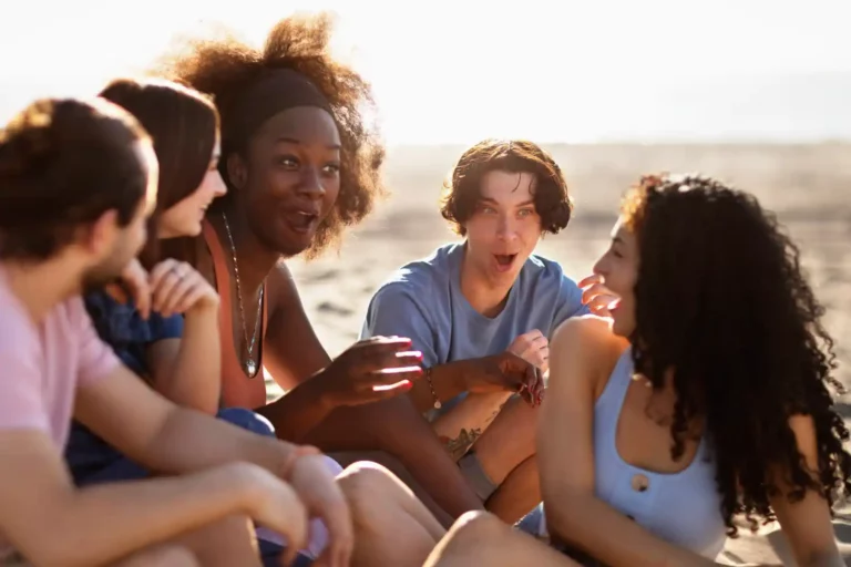 Pessoas conversando na praia. Foto: Freepik