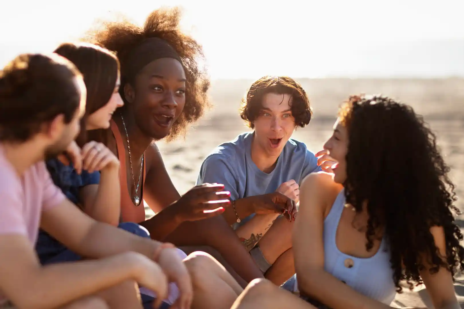 Pessoas conversando na praia. Foto: Freepik