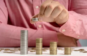 mão fazendo pilhas de moedas
