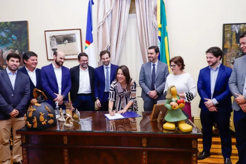pessoas em volta da mesa assinando documento