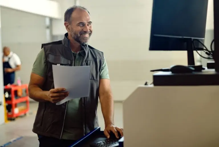 homem operando computador e oficina