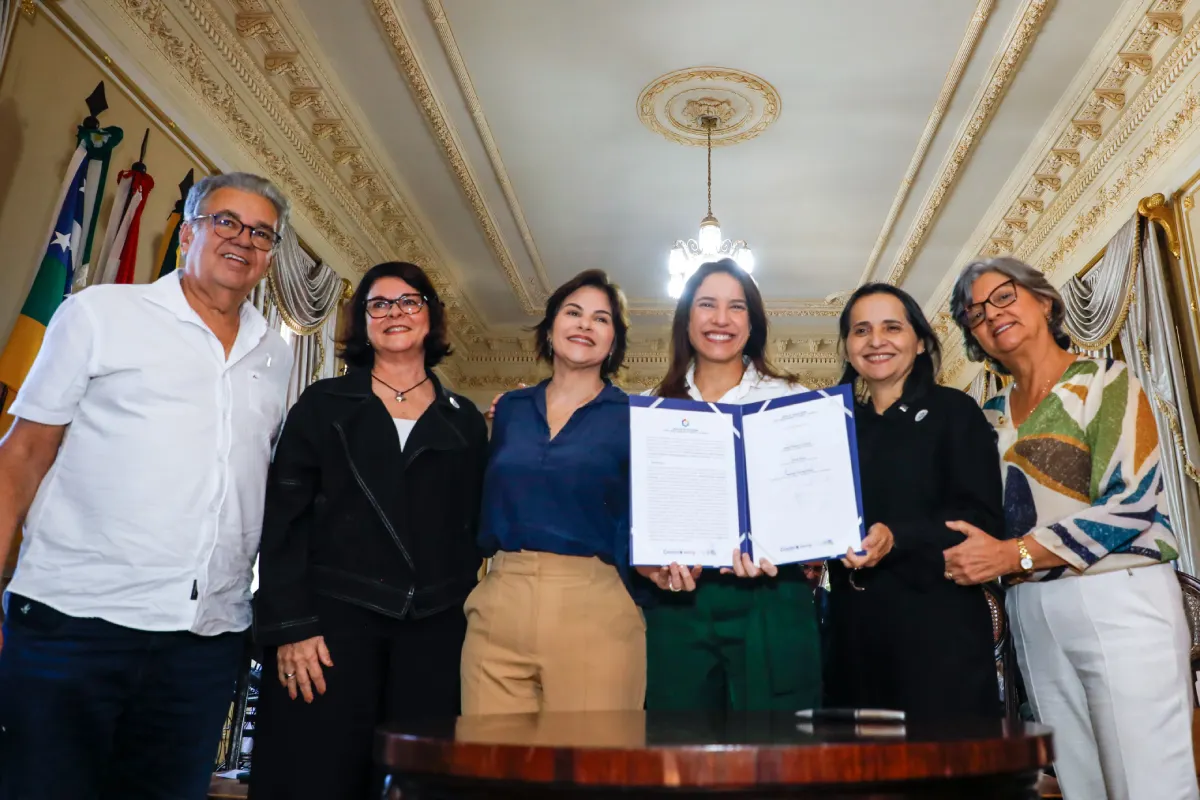 raquellira e conviadados segurando documento