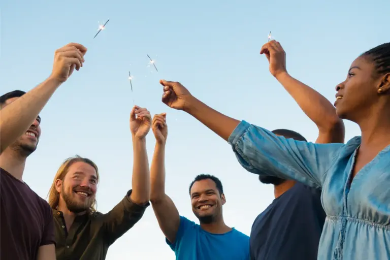Imagem mostra pessoas de diferentes etnias brindando e celebrando