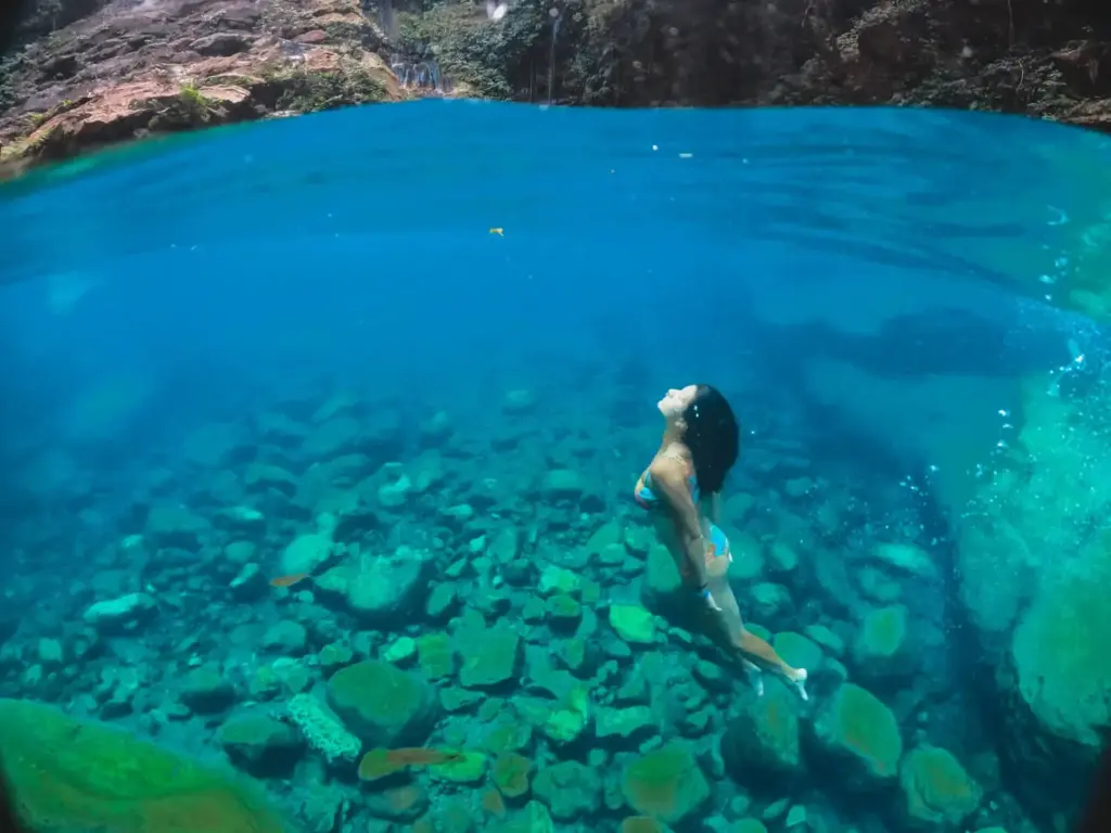 mulher mergulhando no poço azul