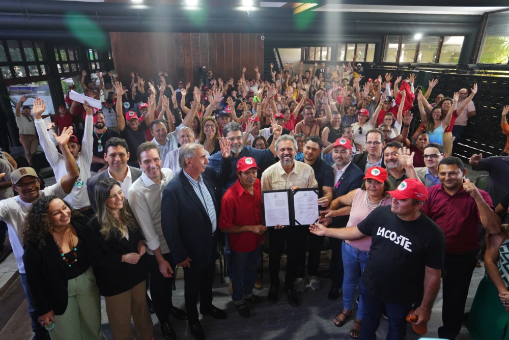 pessoas em auditorio com documento de regulamentação de doação