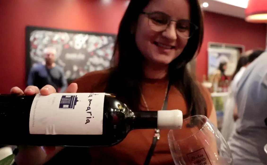 Mulher servindo vinho em uma taça